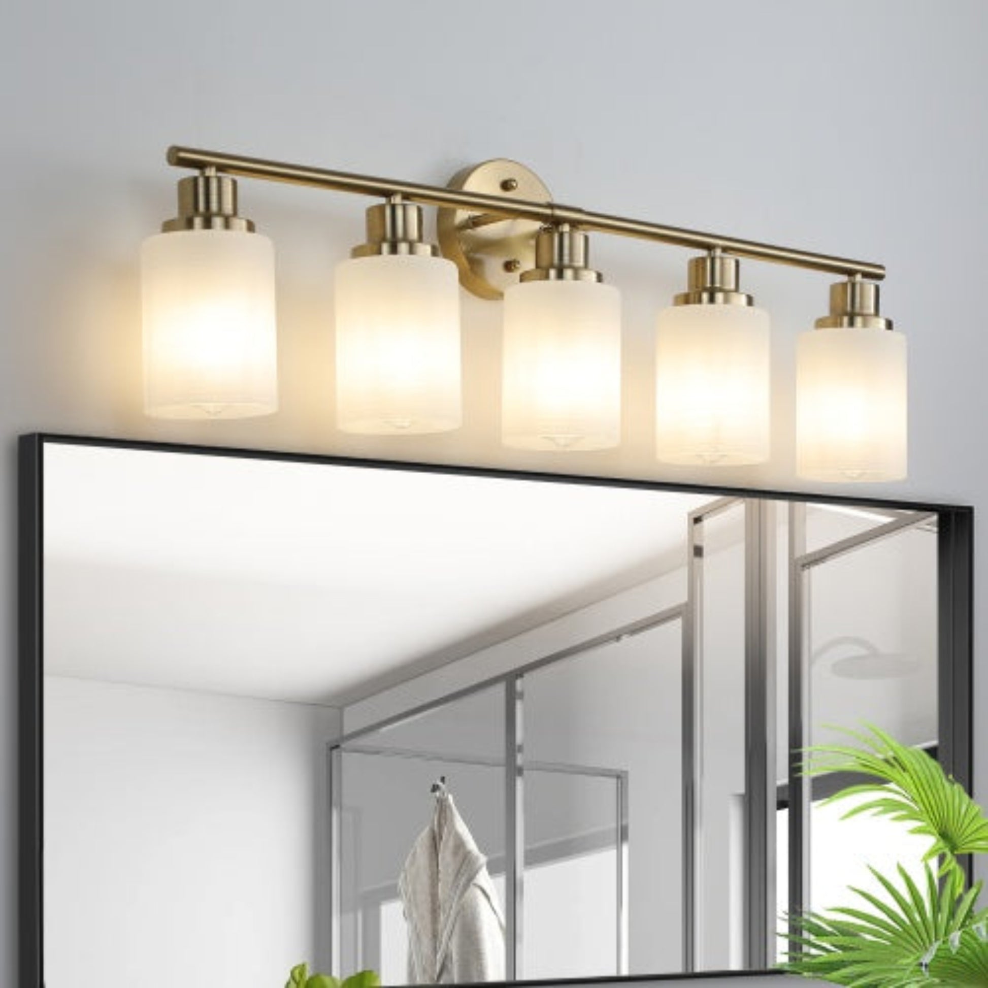 Modern bathroom light fixture with four glass shades above a mirror.