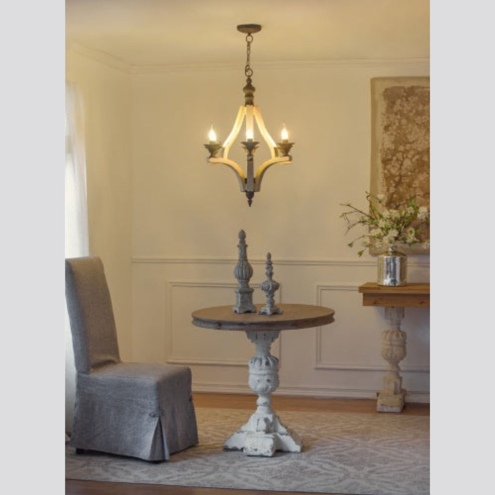Living room with a chandelier, table, and decorative items.