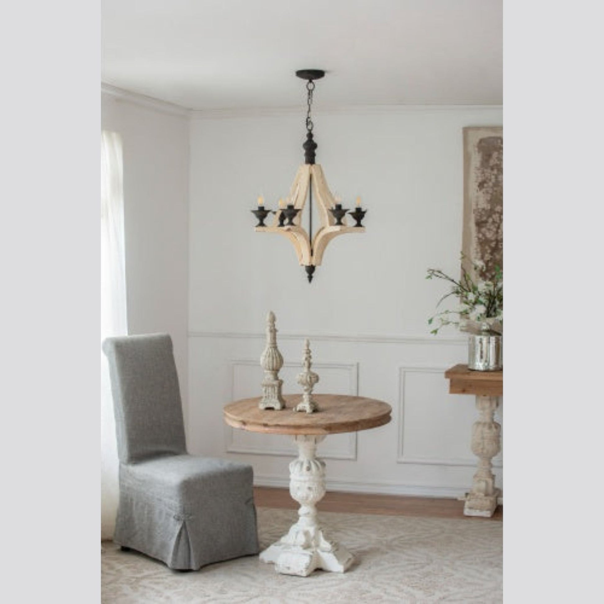 Living room with gray chair, wooden table, and decorative elements.