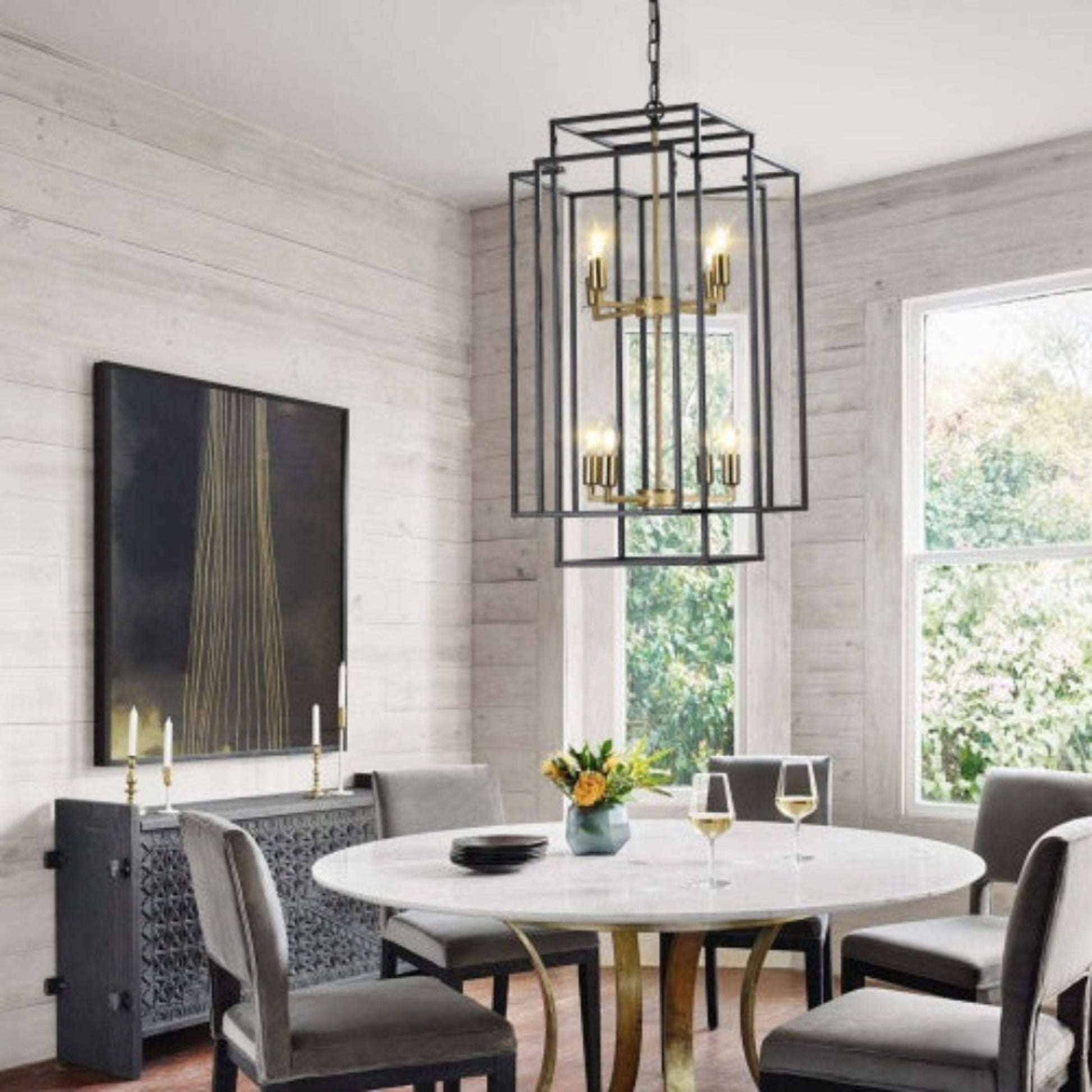 Dining room with round marble table, gray chairs, and a chandelier.