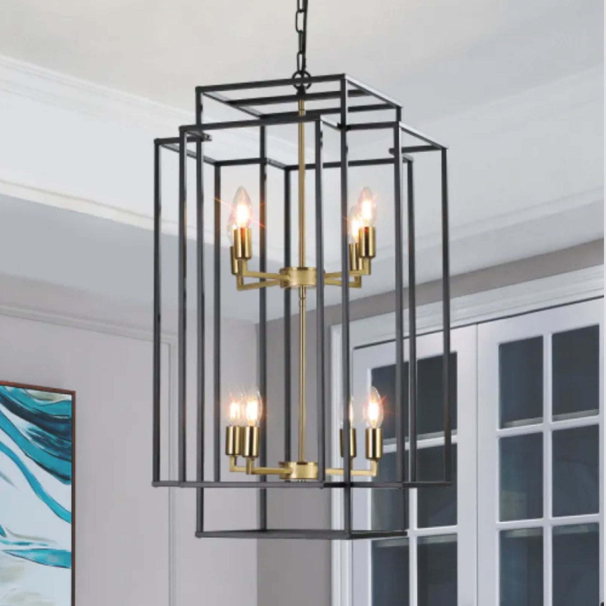 Modern black and gold chandelier hanging in a room with a painting on the wall.