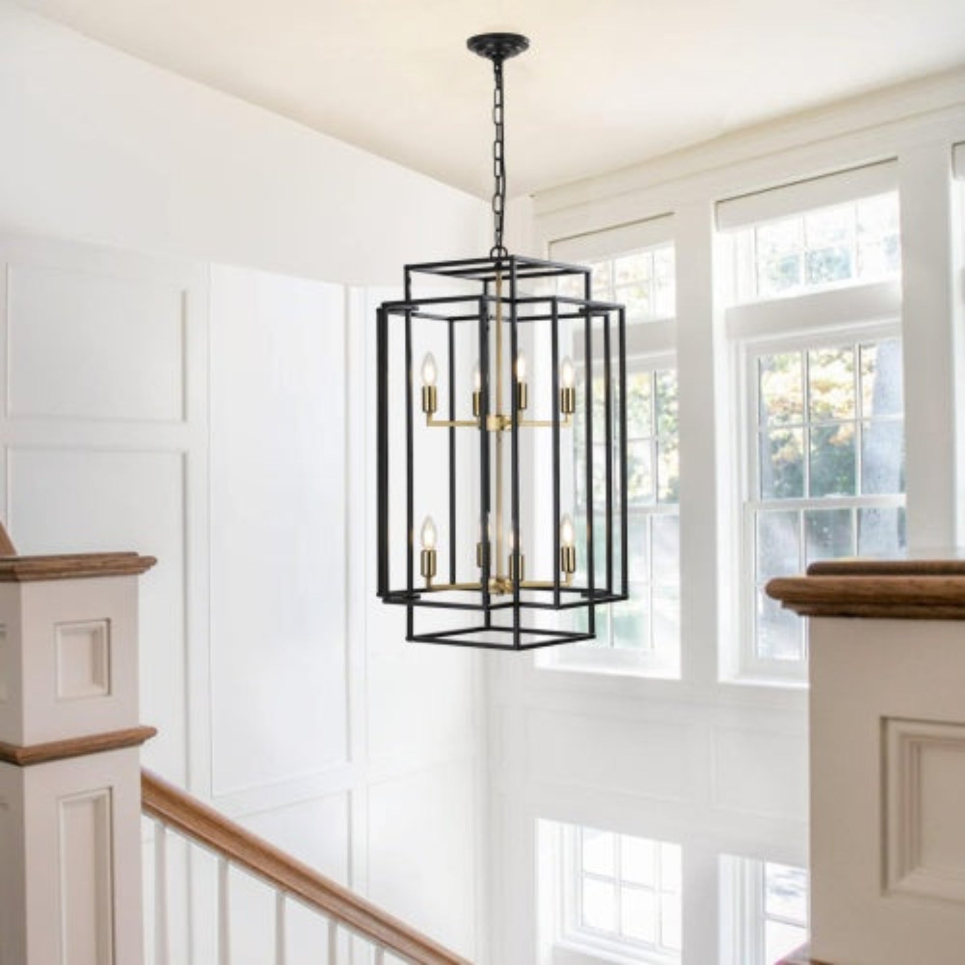 Black pendant light fixture hanging in a room with white walls and large windows.