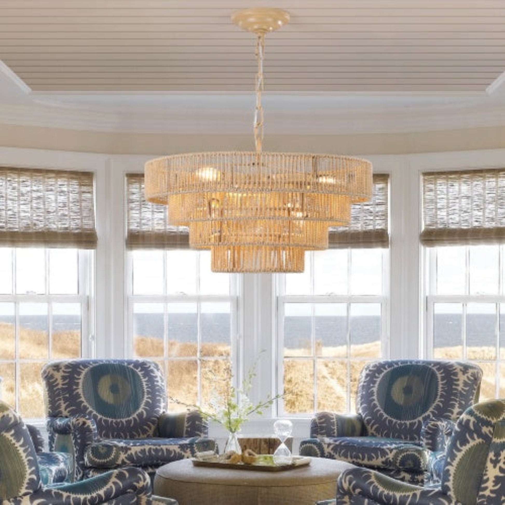 Living room with chandelier, armchairs, and large windows with ocean view