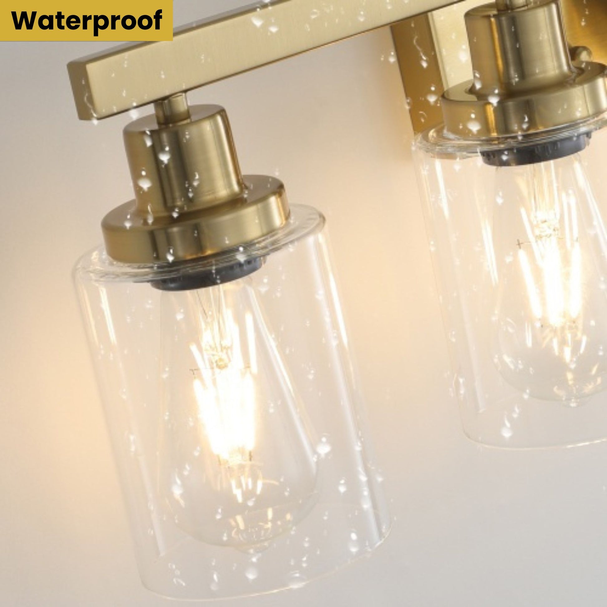 Close-up of a waterproof light fixture with clear glass shades and gold metal accents.