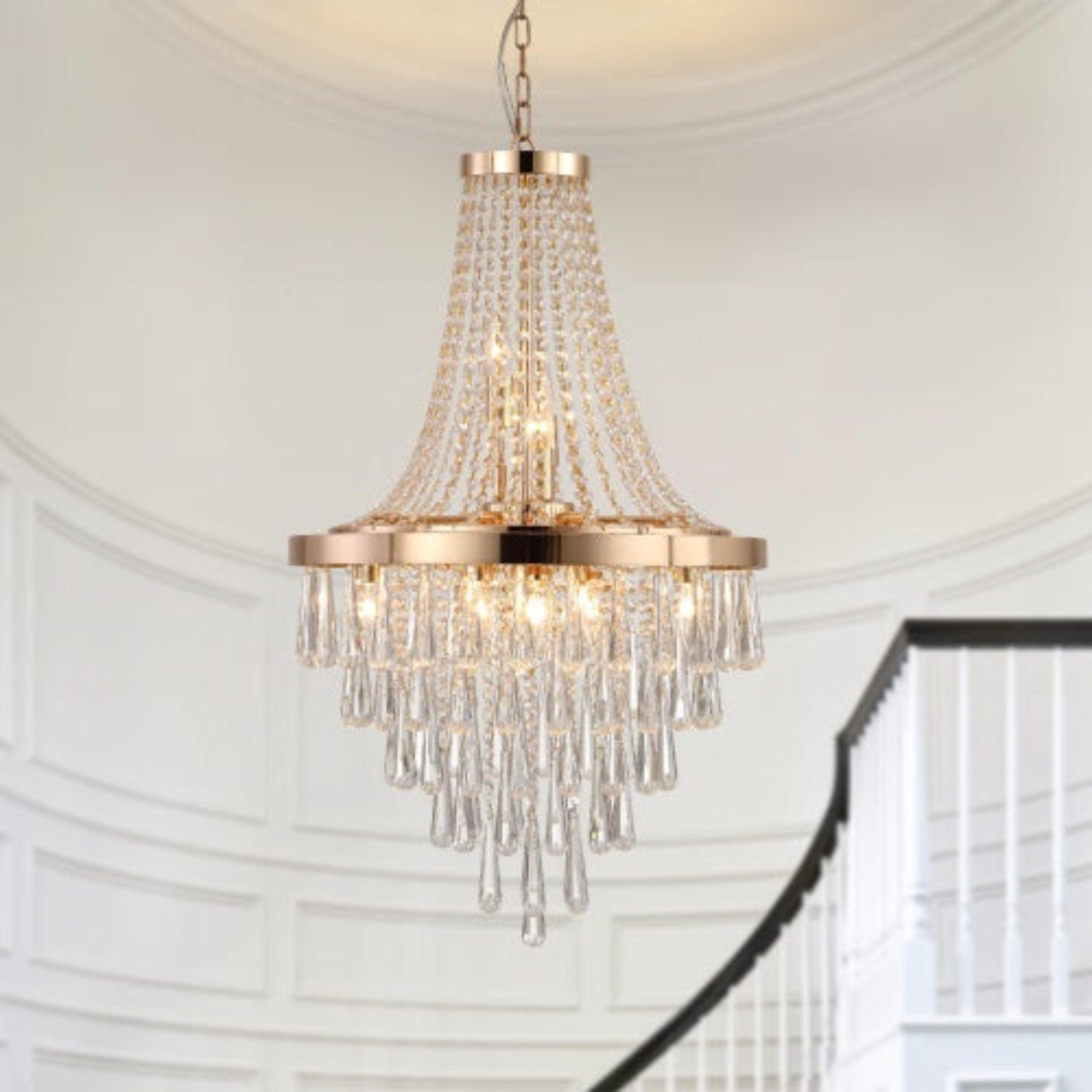 Chandelier with crystal accents hanging in a room with white walls and a staircase.