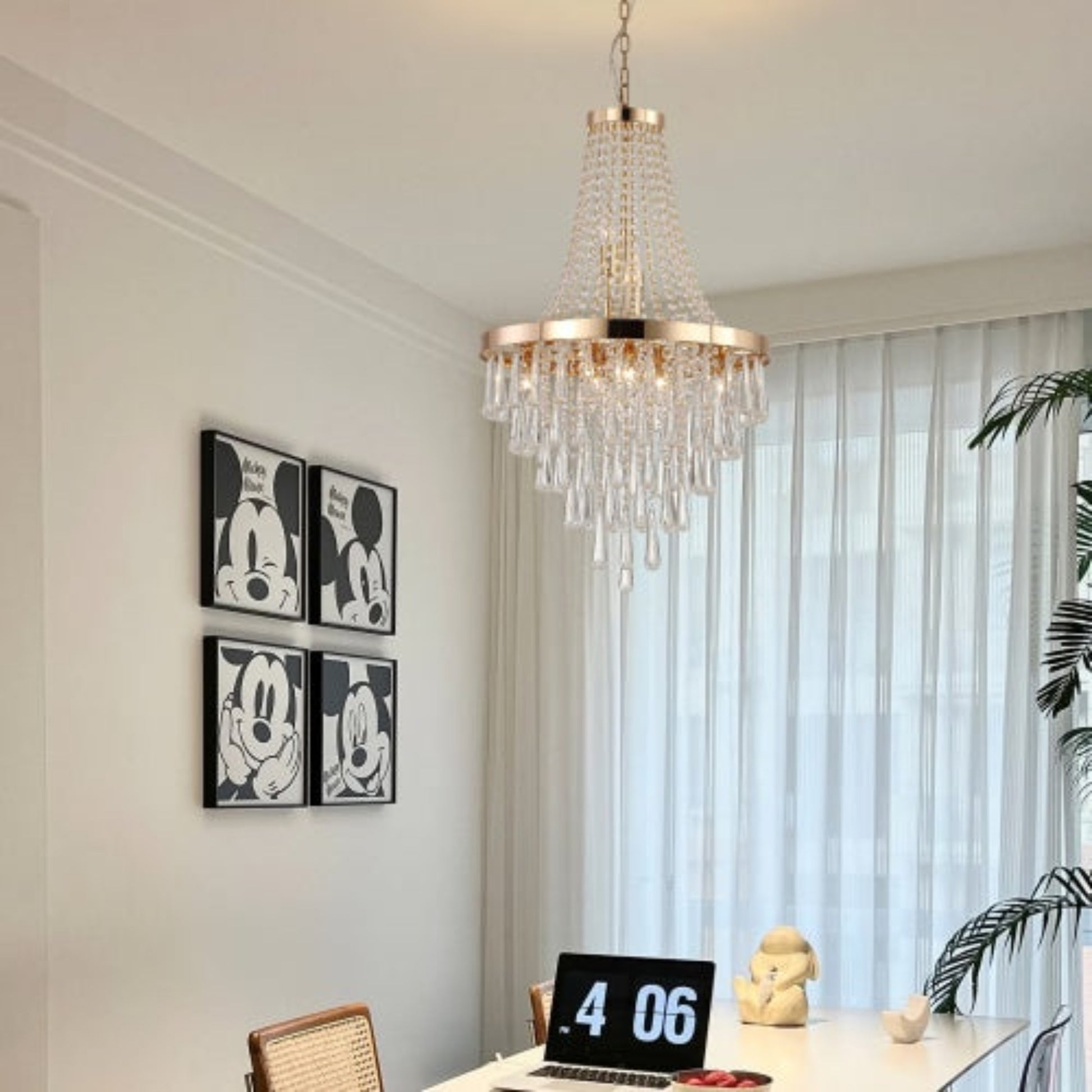 Chandelier hanging above a desk with a laptop, in a room with Mickey Mouse decor.