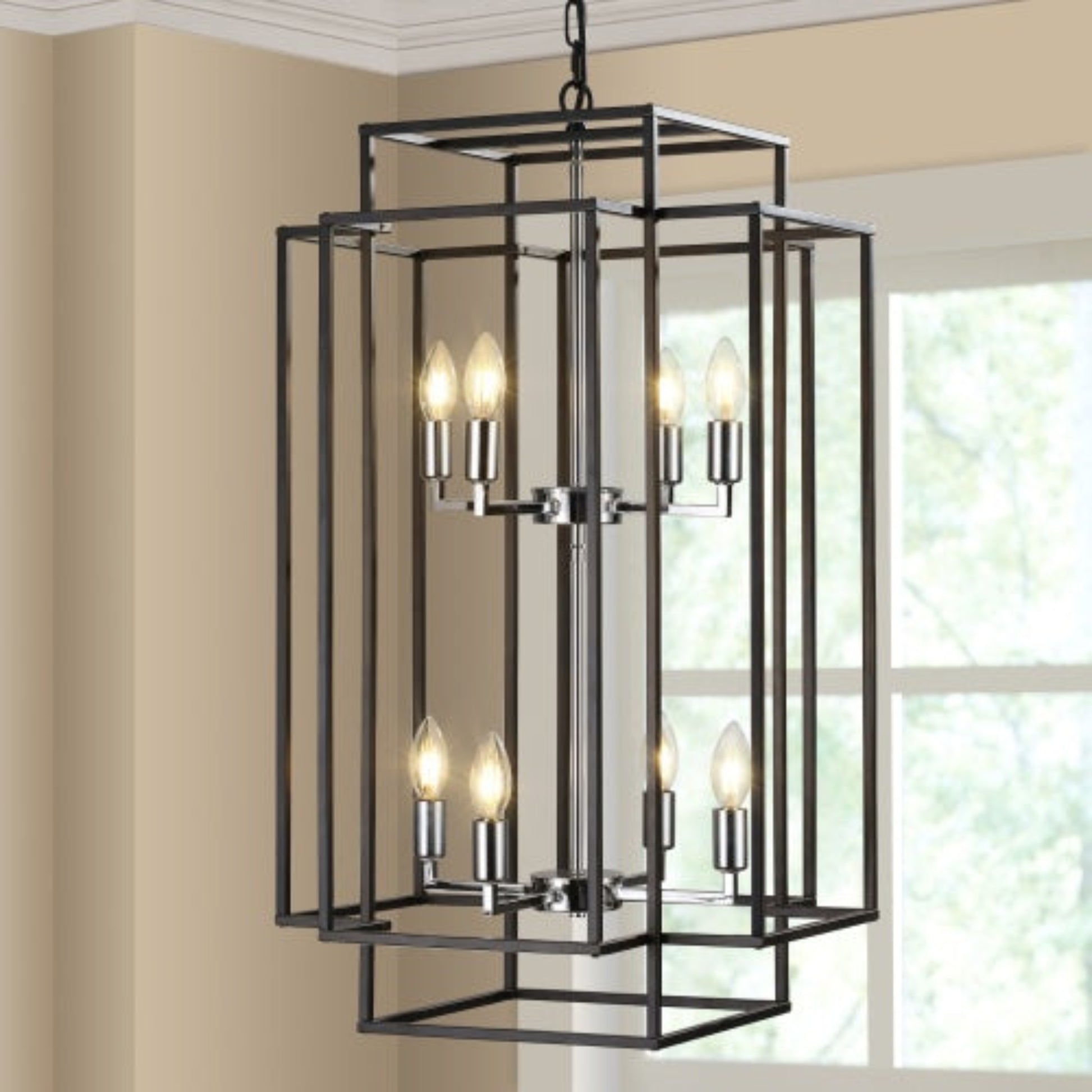 Modern black chandelier hanging in a room with beige walls and a window.