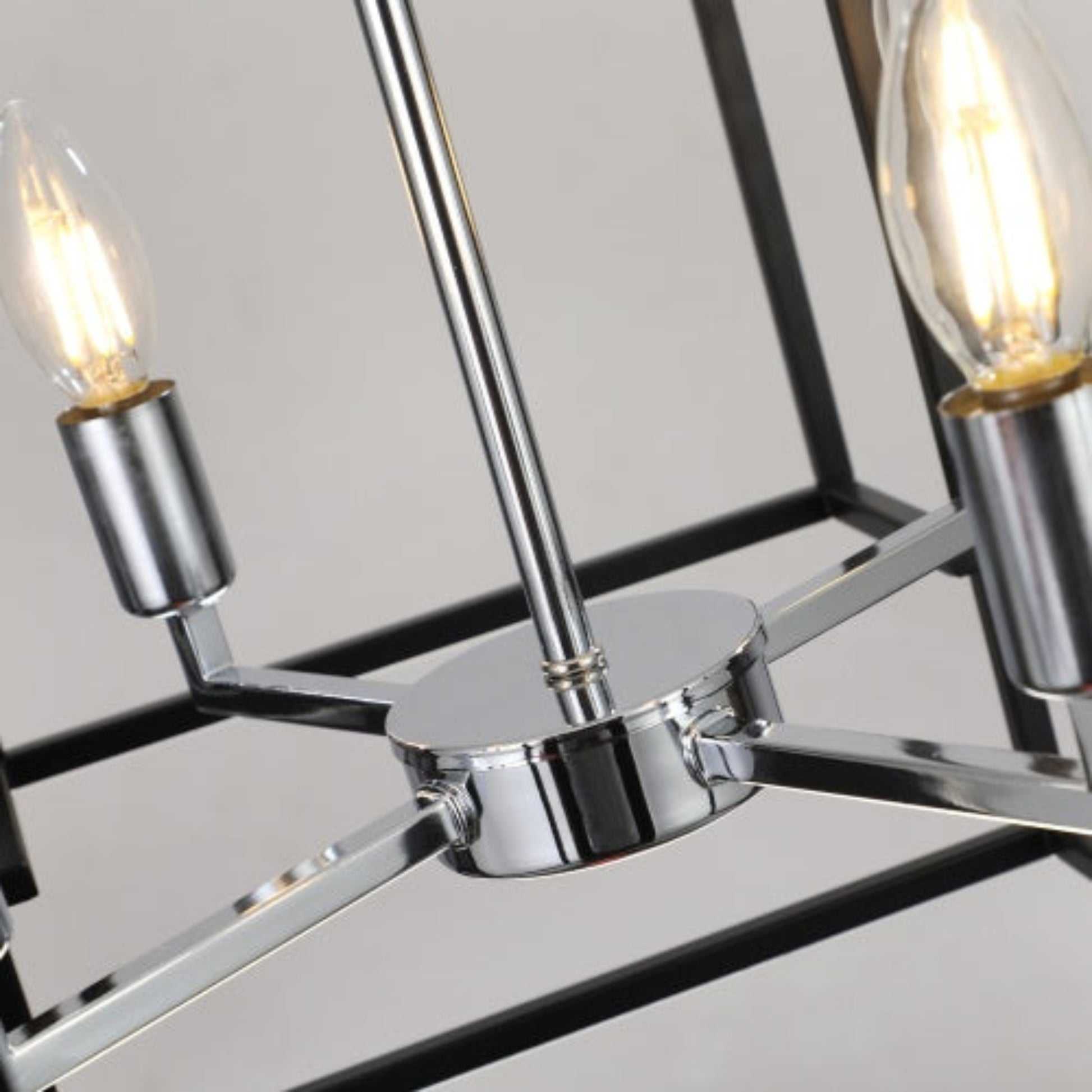 Close-up of a modern chandelier with metallic arms and glass shades.