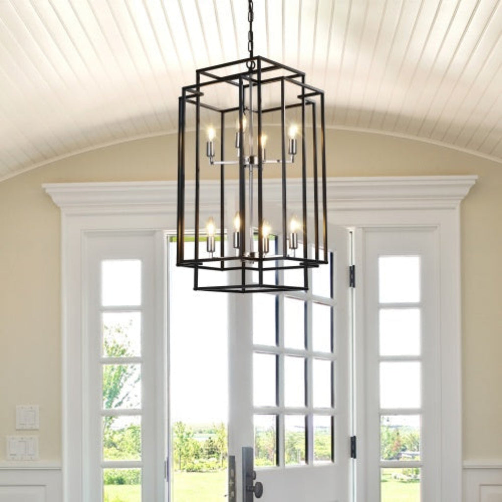 Black chandelier hanging in a room with white walls and French doors.