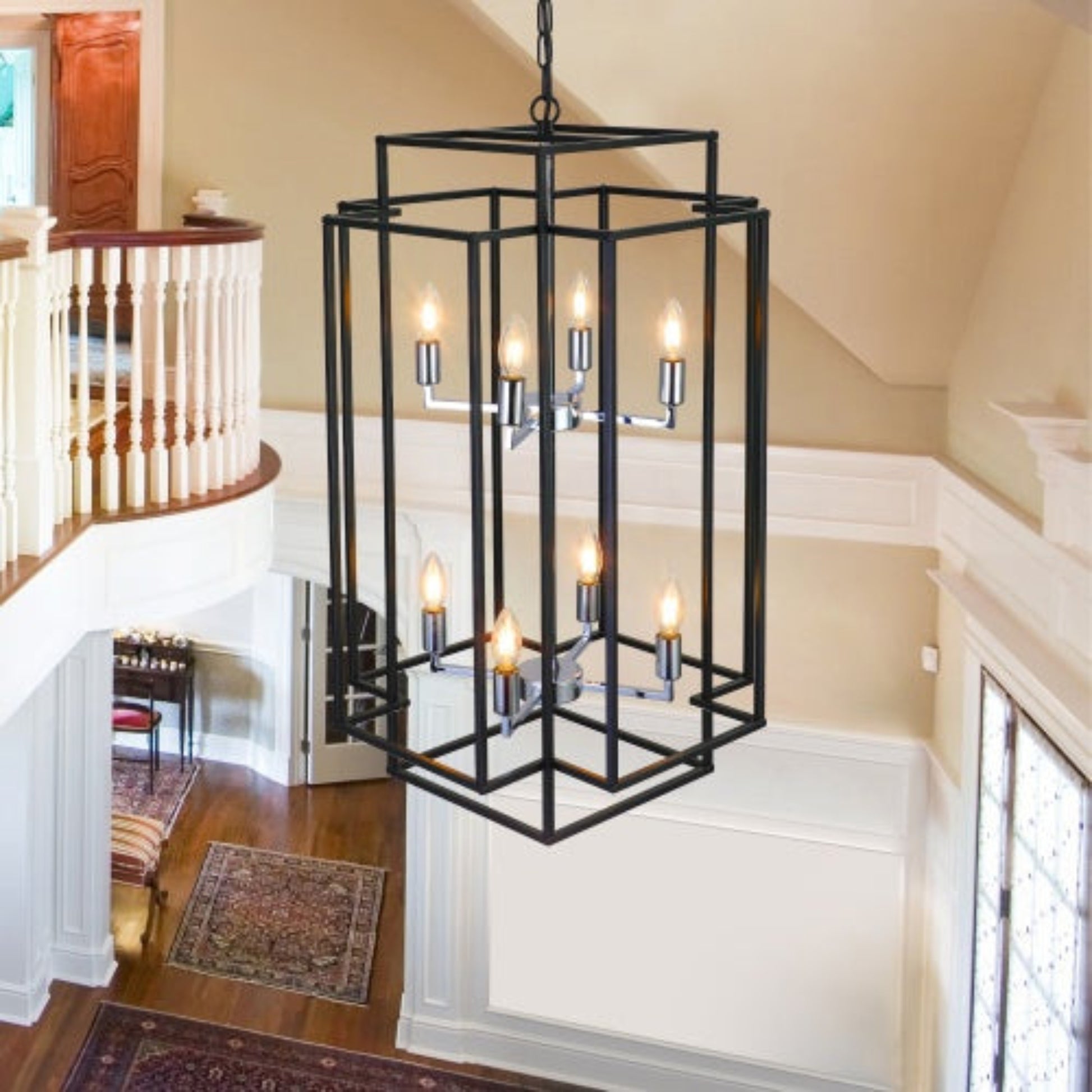 Black metal chandelier hanging in a home interior with staircase and wooden floor.