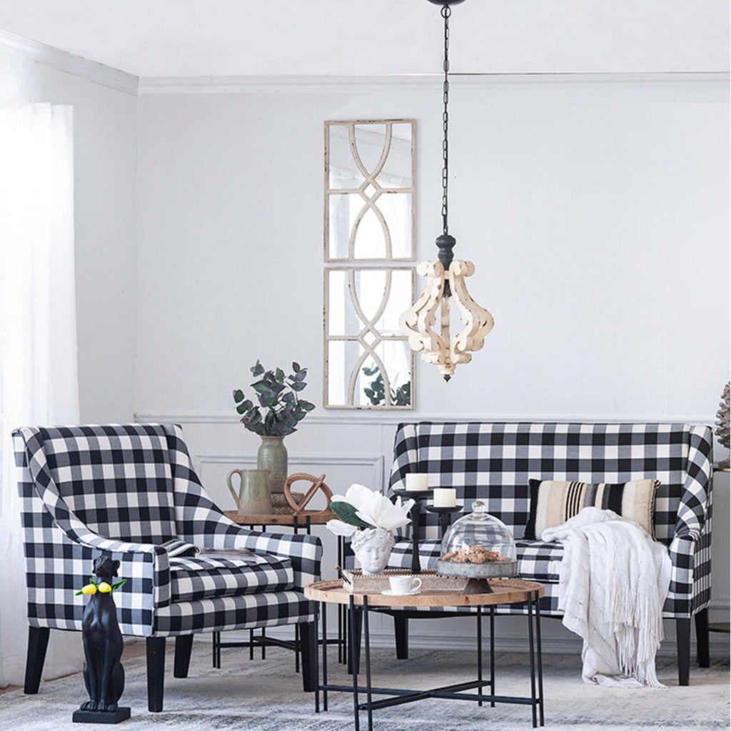 Living room with black and white checkered chairs and sofa, decorative mirror, and coffee table.