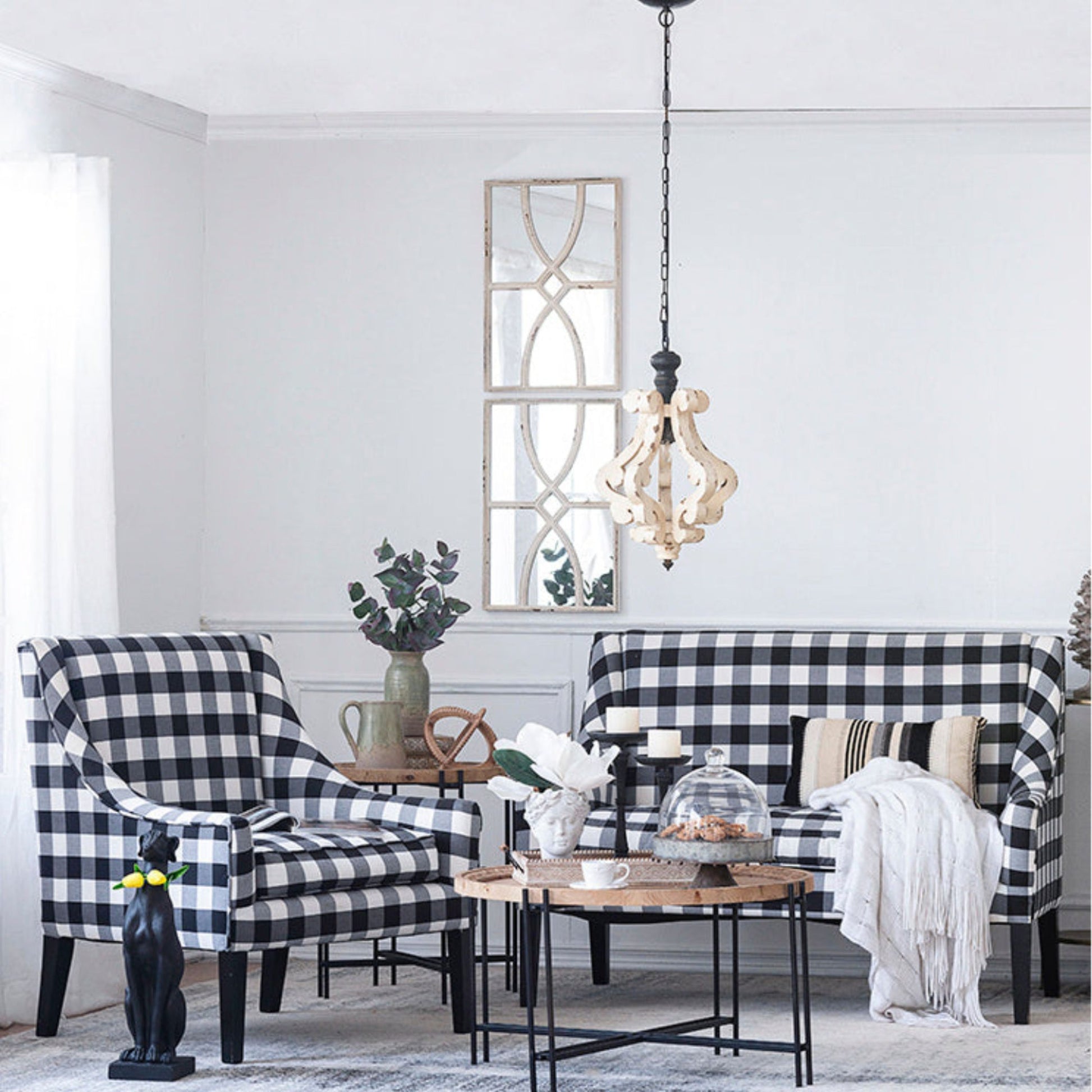 Living room with black and white checkered chairs and sofa, decorative mirror, and coffee table.